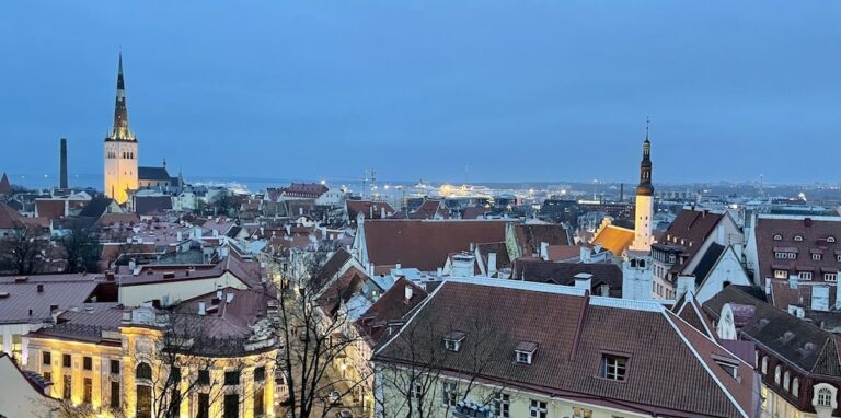 Tallinn Old Town rooftops at dusk, church spires above the medieval skyline