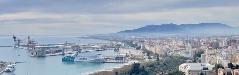 Malaga from above: the port and cranes on the left, the city and mountains beyond